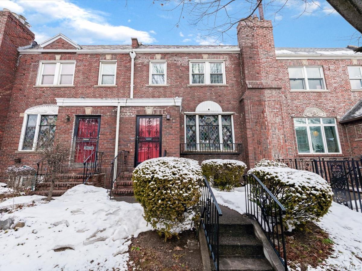 View of front of house with a chimney and brick siding.