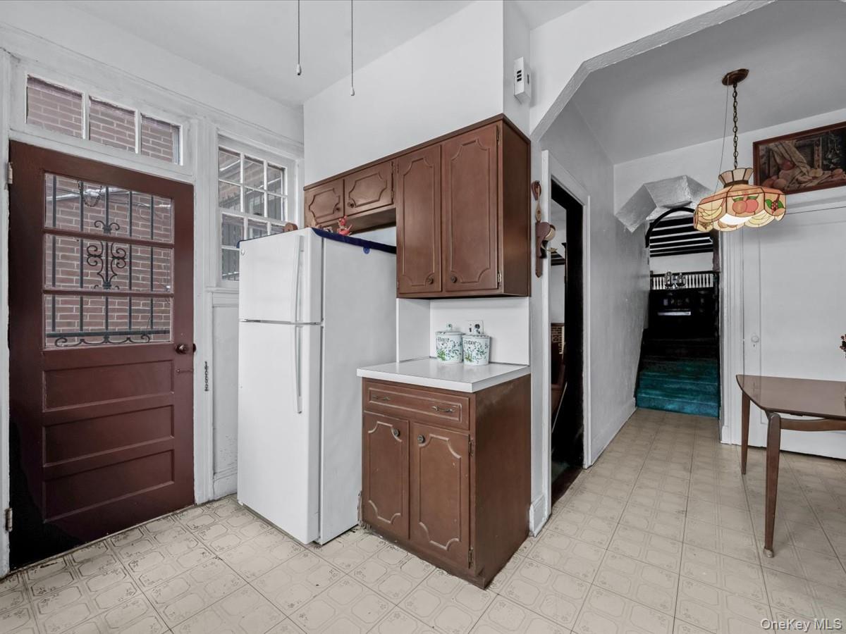 140-17 58th Road Queens, NY 11355 - Photo 11 of 25 a kitchen with kitchen island a refrigerator and a stove top oven