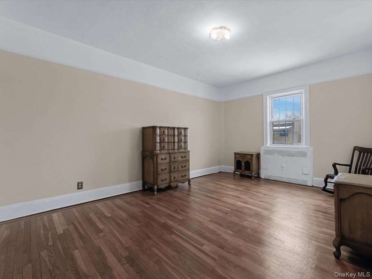 140-17 58th Road Queens, NY 11355 - Photo 12 of 25 an empty room with wooden floor and windows