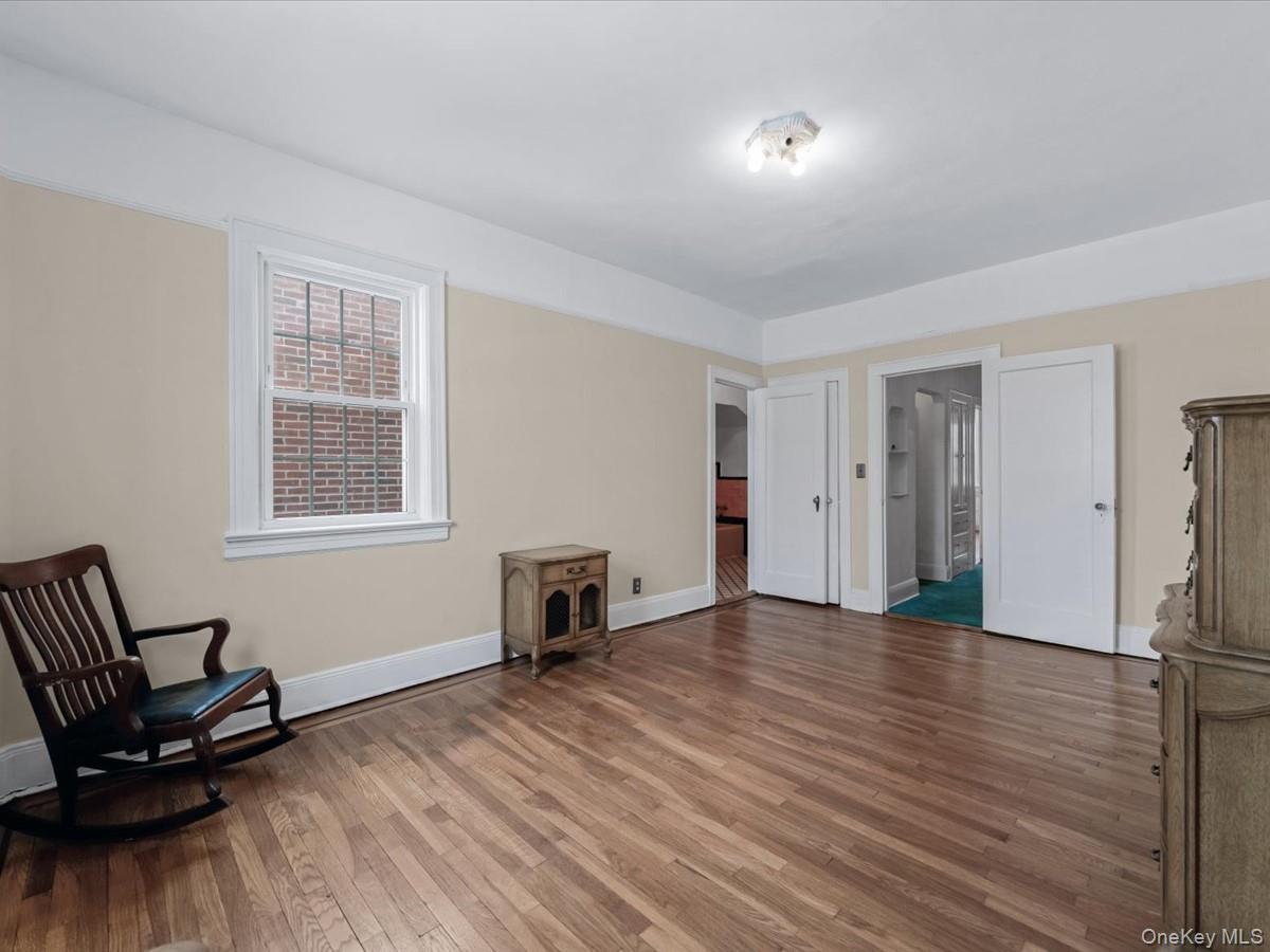 140-17 58th Road Queens, NY 11355 - Photo 13 of 25 a view of a livingroom with wooden floor and a window