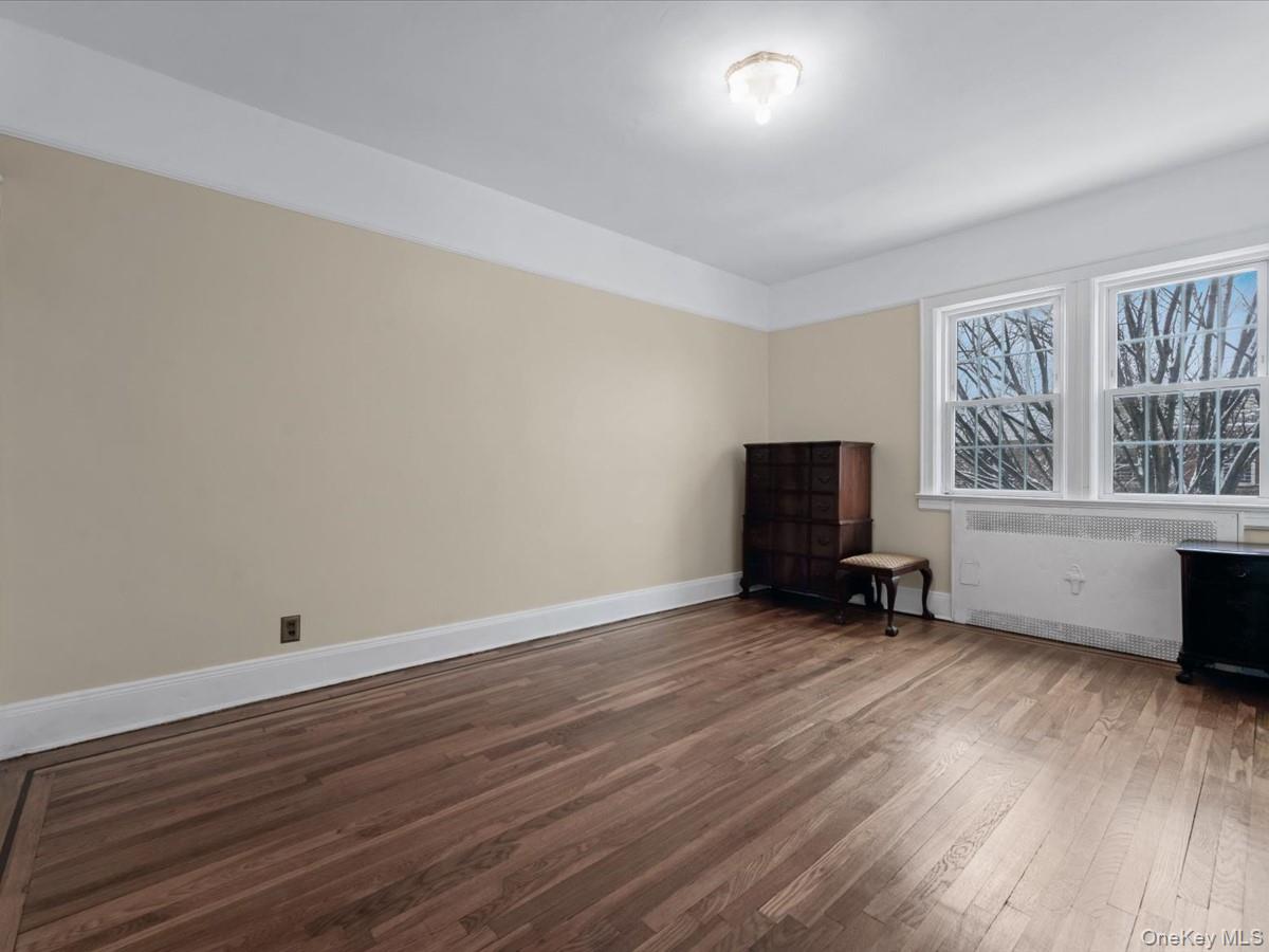140-17 58th Road Queens, NY 11355 - Photo 14 of 25 an empty room with wooden floor and windows
