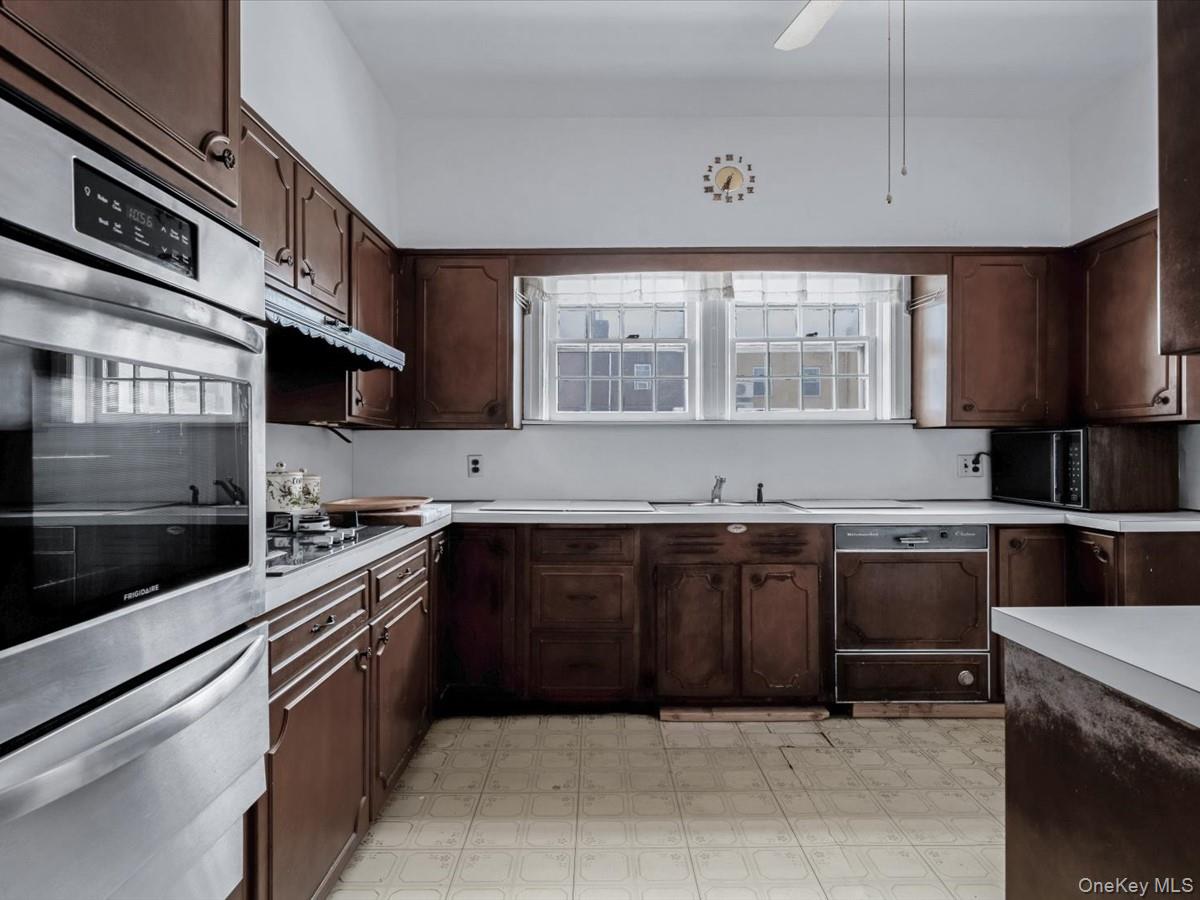 140-17 58th Road Queens, NY 11355 - Photo 9 of 25 a kitchen with a sink stove and microwave