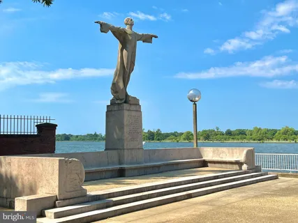 a front view of a building with glass windows and plants