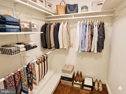 a view of walk in closet with clothes and shoes