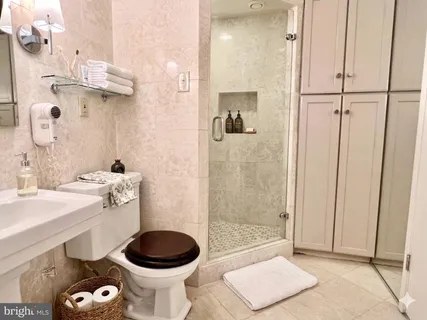 a bathroom with a granite countertop sink a toilet and shower