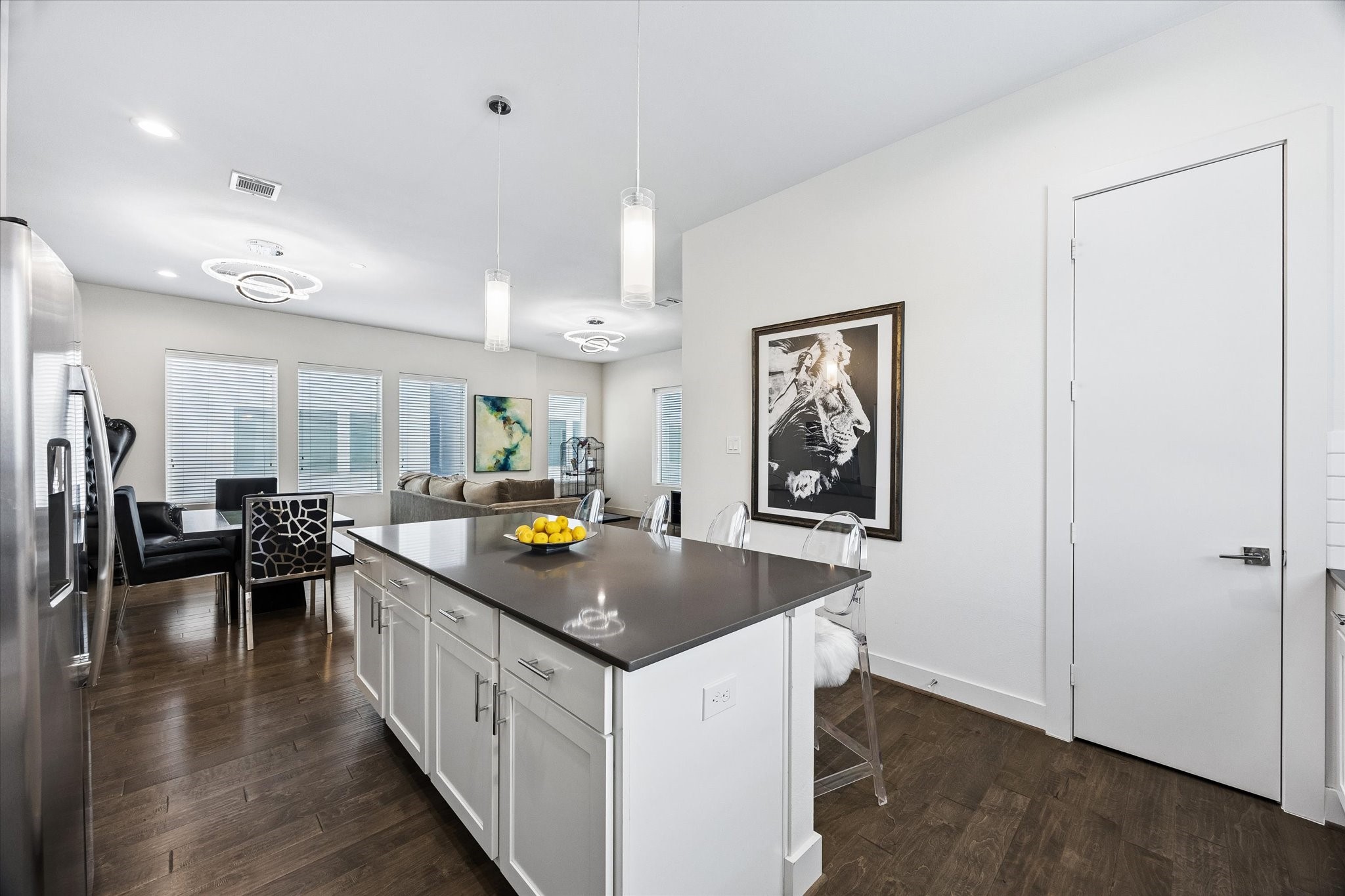 1310 Hussion Street Houston, TX 77003 - Photo 11 of 34 This open-concept kitchen and living area features a large island with white cabinetry. Modern pendant lights and ample natural light create a bright, inviting space.