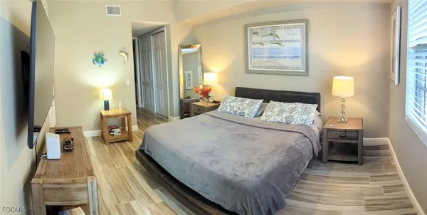 a bedroom with a bed and wooden floor