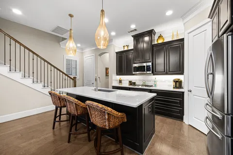 a kitchen with stainless steel appliances a dining table chairs refrigerator and stove