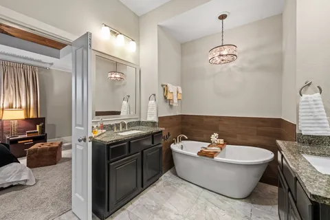 a bathroom with a granite countertop sink a mirror and bathtub