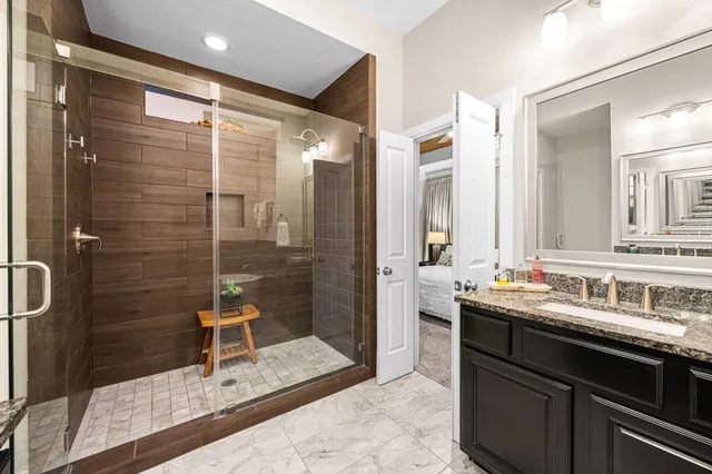 a bathroom with a double vanity sink mirror and shower
