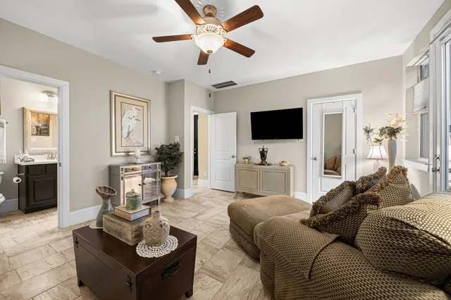 a living room with furniture a flat screen tv and kitchen view