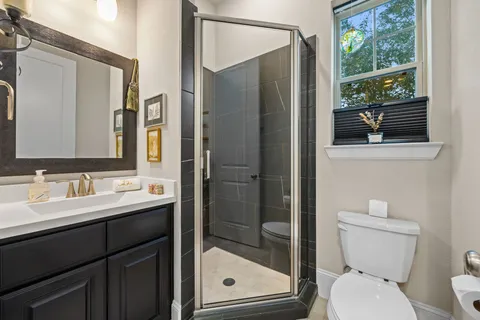 a bathroom with a toilet a sink and glass door