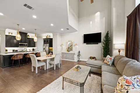 a living room with furniture a flat screen tv and kitchen view