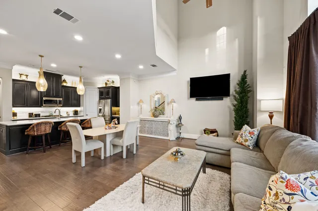 a living room with furniture a flat screen tv and kitchen view