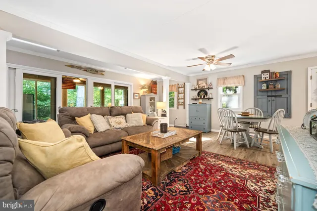 a living room with furniture a table and a large window