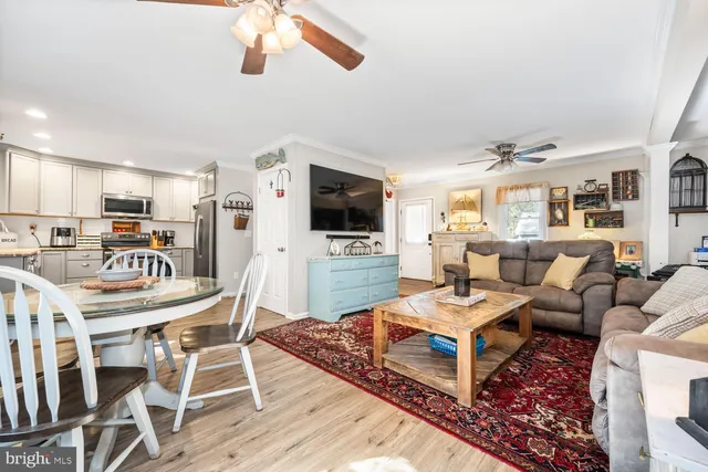 a living room with furniture a flat screen tv and kitchen view