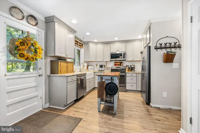 a kitchen with stainless steel appliances granite countertop a refrigerator sink and stove