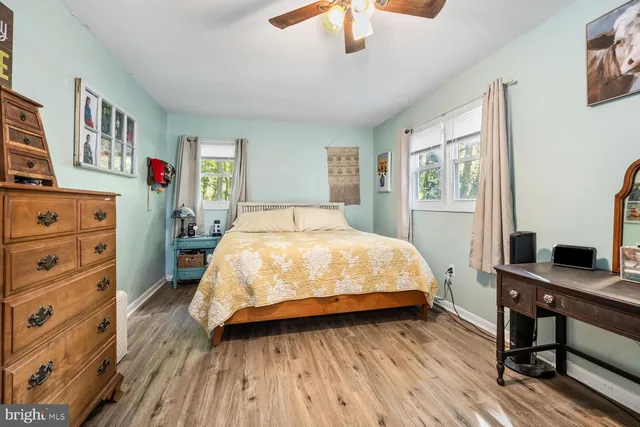 a bed sitting in a bedroom next to a window with a bookshelf