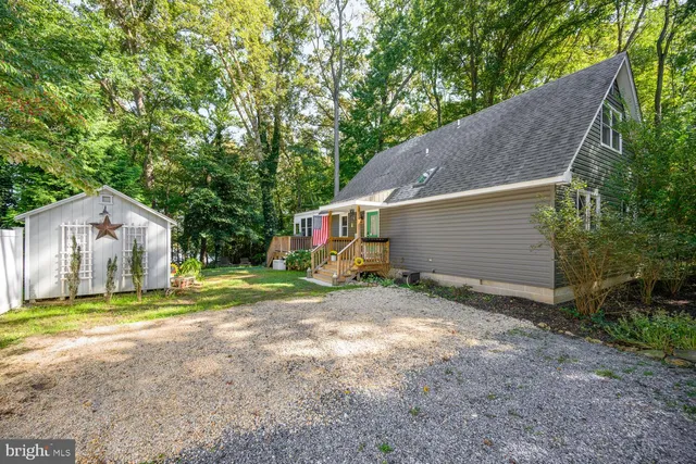 a view of a house with backyard and trees