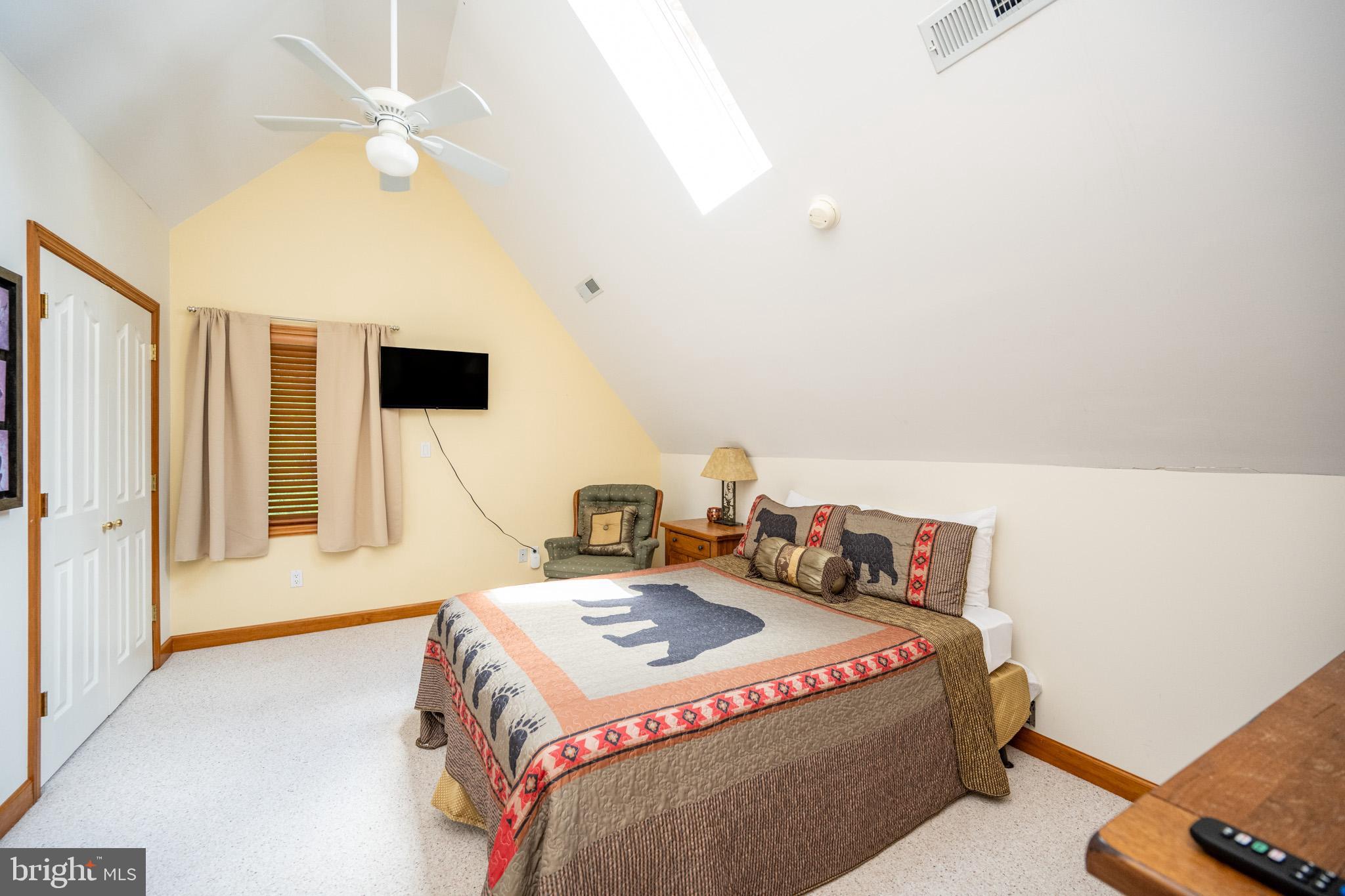 201 Rock Lodge Road McHenry, MD 21541 - Photo 36 of 75 a bedroom with a bed and a flat tv screen on the dresser