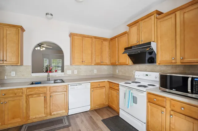 a kitchen with granite countertop a sink cabinets and stainless steel appliances
