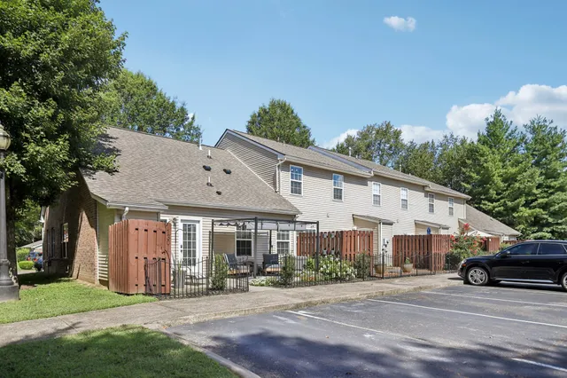 a view of a white house next to a yard and trees