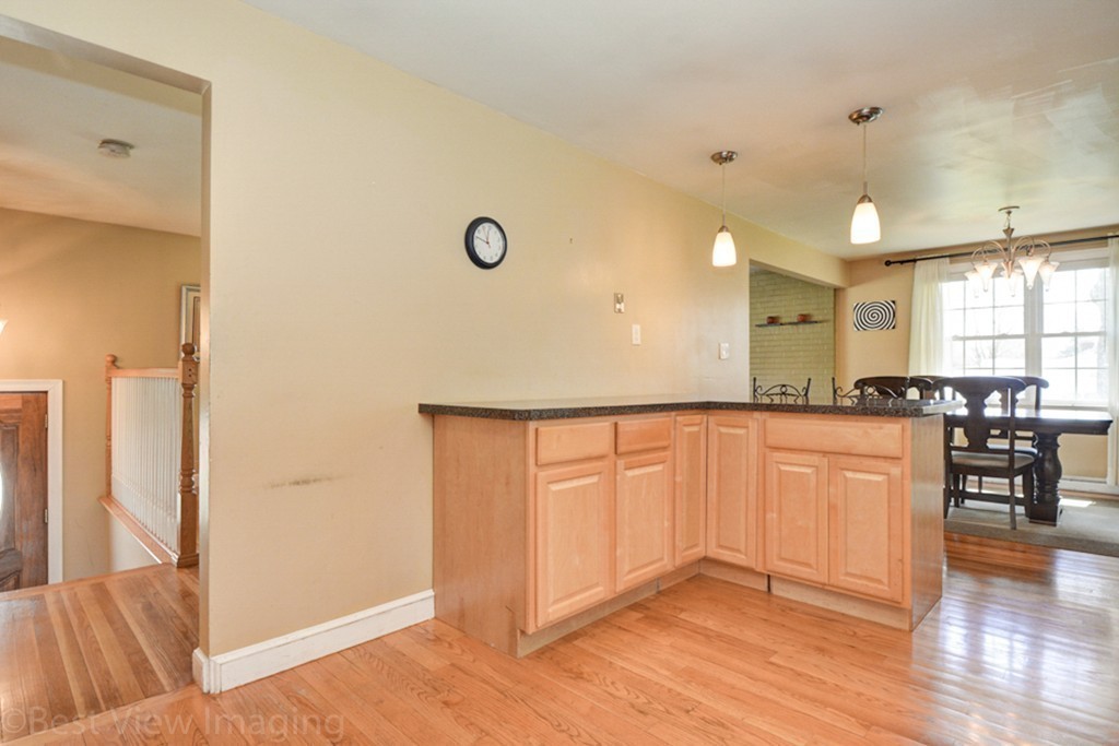 59 Amor Road Milton, MA 02186 - Photo 17 of 29 a open kitchen with white cabinets and wooden floor