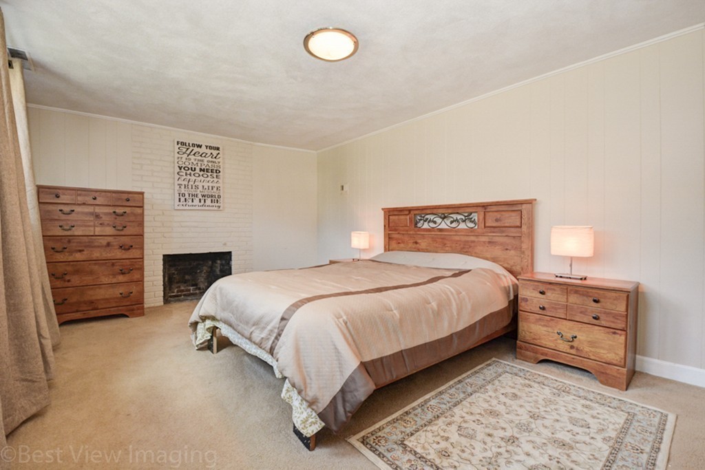 59 Amor Road Milton, MA 02186 - Photo 22 of 29 a spacious bedroom with a bed and a fireplace