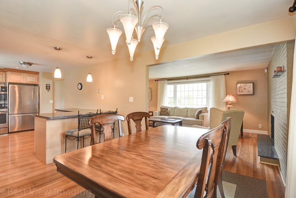 59 Amor Road Milton, MA 02186 - Photo 7 of 29 a dining room with wooden floor a chandelier a wooden table and chairs