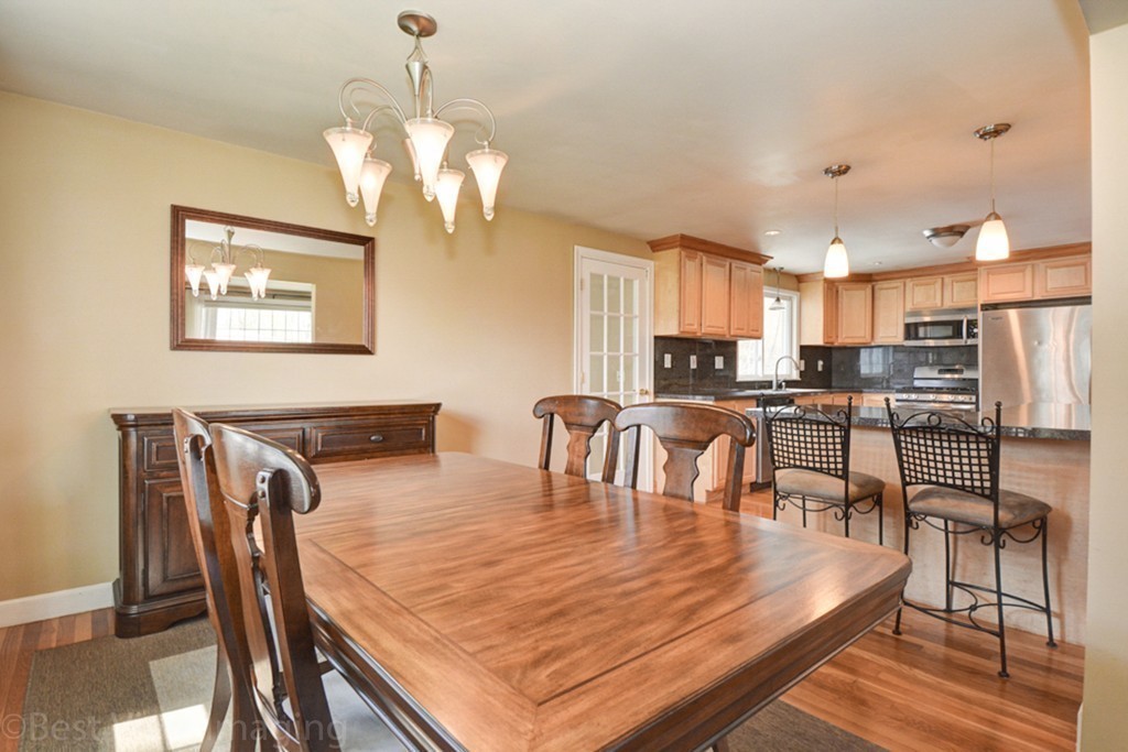 59 Amor Road Milton, MA 02186 - Photo 8 of 29 a dining room with wooden floor a chandelier a glass table and chairs