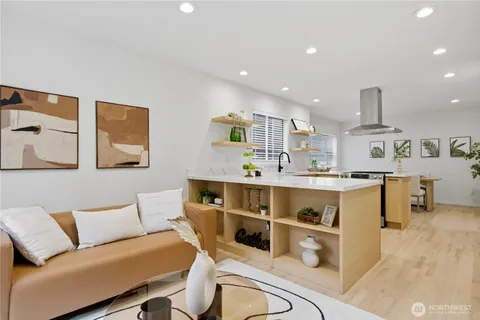 a view of kitchen with stainless steel appliances furniture stove and wooden floor