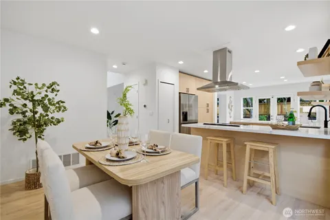 a kitchen with stainless steel appliances kitchen island a table and chair in it