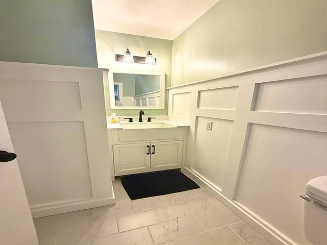 a bathroom with a sink a toilet and a mirror