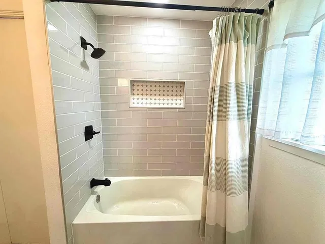 a bathroom with bathtub and shower