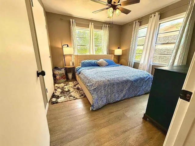 a bedroom with a bed and wooden floor