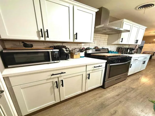 a kitchen with white cabinets and white appliances