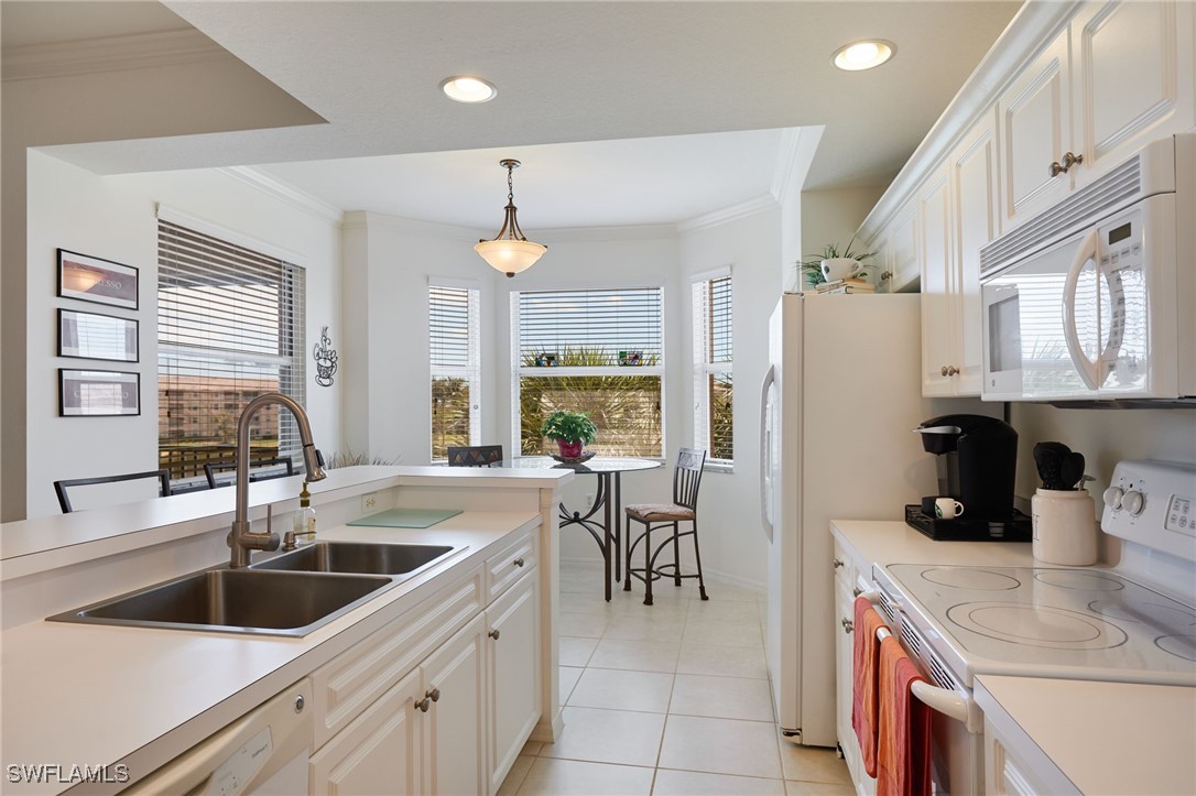 8550 Kingbird Loop, Unit 637 Estero, FL 33967 - Photo 18 of 35 a kitchen that has a sink a refrigerator and a sink