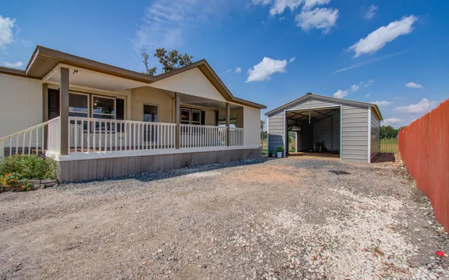a view of a house with a yard and porch