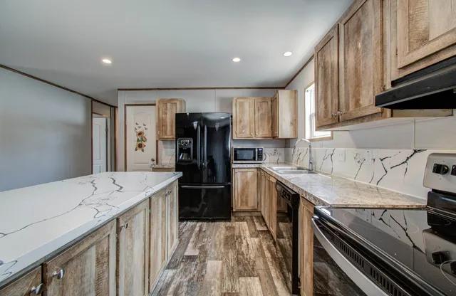 a kitchen with a sink a refrigerator and cabinets