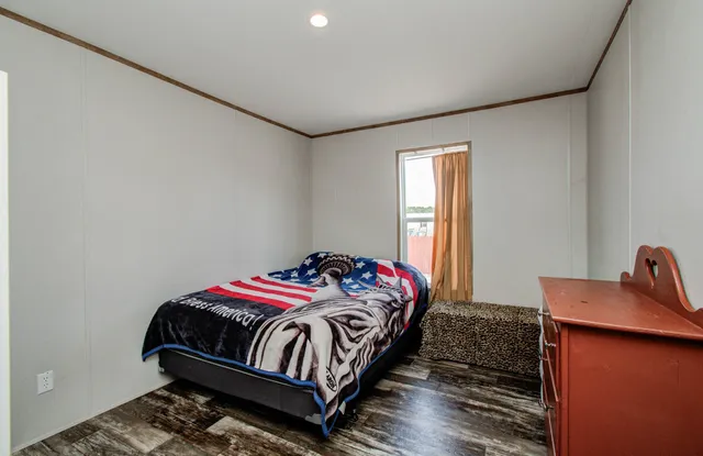 a bedroom with a bed and wooden floor