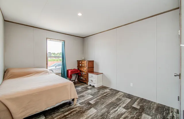 a bedroom with a bed and wooden floor