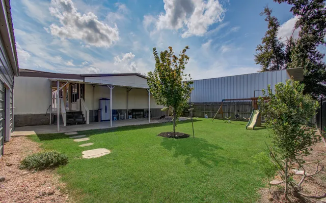 a view of a house with a backyard and a slide