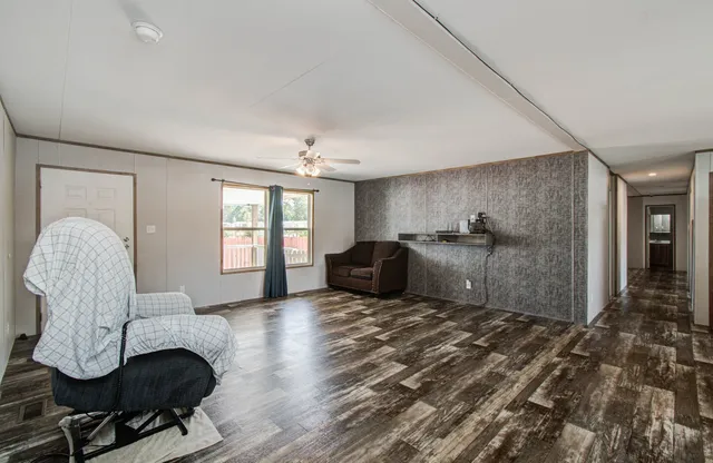 a living room with furniture a chandelier and a large window