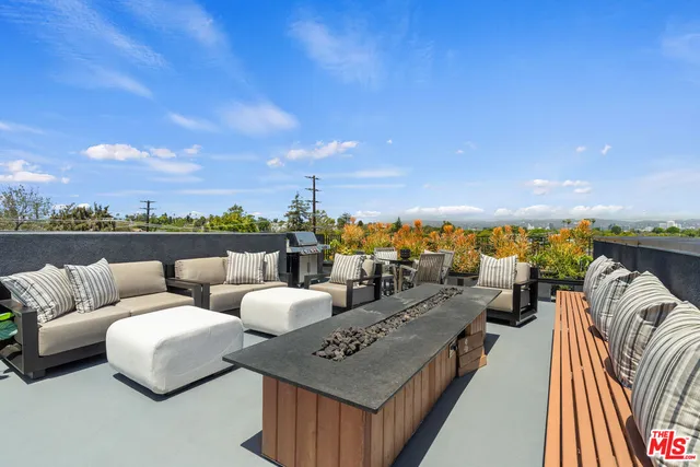 a roof deck with couches and city view