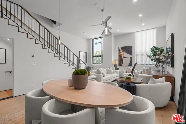 a living room with furniture a potted plant and a table