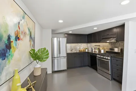 a kitchen with stainless steel appliances granite countertop a refrigerator and a sink