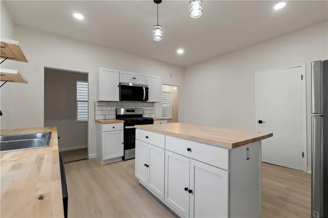 a kitchen with cabinets a sink and appliances