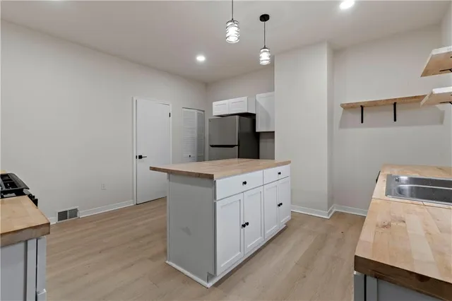 a kitchen with white cabinets sink and stainless steel appliances