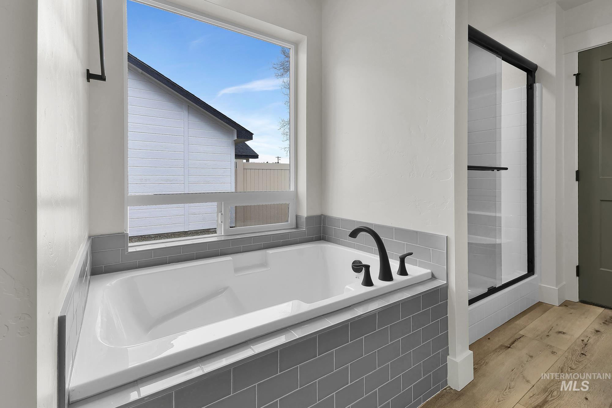 1130 Velvet Loop Wilder, ID 83676 - Photo 23 of 35 Soaking tub with matte black fixtures, surrounded by gray subway tile
