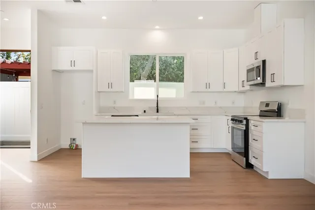 an empty room with wooden floor and natural light